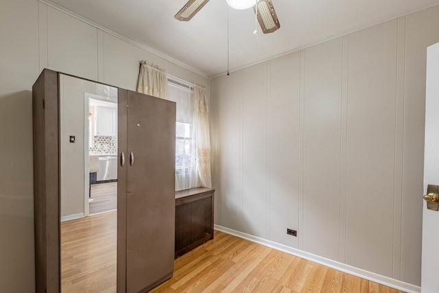 2535 Oak Park Ave, Berwyn, IL 60402 - unfurnished room featuring light wood-style floors, a ceiling fan, baseboards, a decorative wall, and crown molding