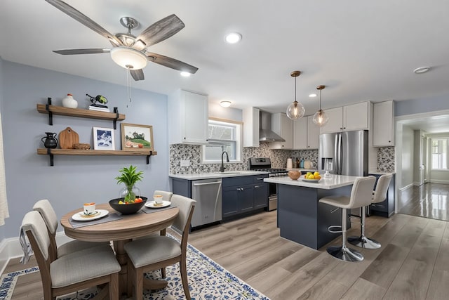 2535 Oak Park Ave, Berwyn, IL 60402 - kitchen with stainless steel appliances, a sink, light countertops, a kitchen breakfast bar, and tasteful backsplash
