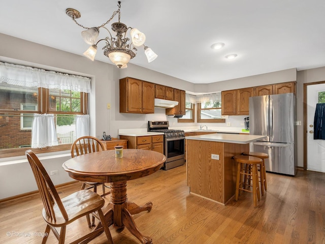 824 Dawes Ave, Wheaton, IL 60189 - kitchen with appliances with stainless steel finishes, a chandelier, brown cabinets, and light wood-style flooring