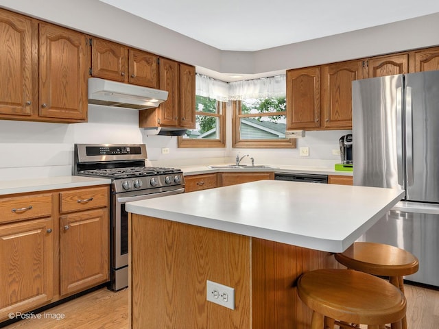 824 Dawes Ave, Wheaton, IL 60189 - kitchen with appliances with stainless steel finishes, under cabinet range hood, a breakfast bar area, and brown cabinets