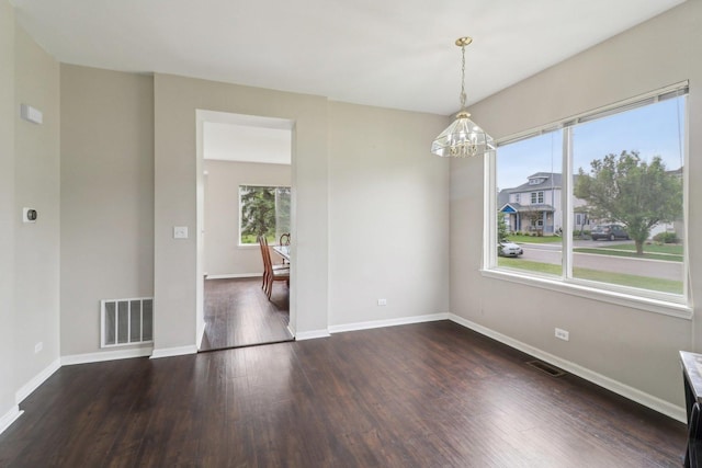 801 S Parkside Dr, Round Lake, IL 60073 - empty room featuring a chandelier, dark wood-type flooring, and baseboards