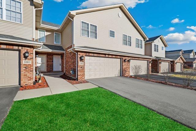 1005 Regent Dr, Matteson, IL 60443 - townhome / multi-family property with brick siding, an attached garage, and driveway