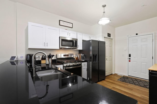 1005 Regent Dr, Matteson, IL 60443 - kitchen with stainless steel appliances, a sink, white cabinetry, wood finished floors, and hanging light fixtures
