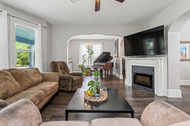 1104 W Church St, Champaign, IL 61821 - living area with arched walkways, ceiling fan, wood finished floors, a tiled fireplace, and baseboards