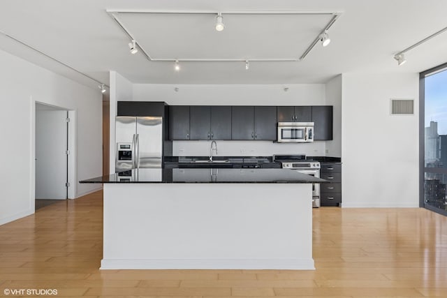 860 W Blackhawk St Unit 2102, Chicago, IL 60642 - kitchen featuring appliances with stainless steel finishes, dark countertops, dark cabinets, a sink, and a kitchen island with sink