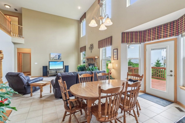 8610 Pebble Creek Ct, Wonder Lake, IL 60097 - dining space featuring light tile patterned floors, a high ceiling, a chandelier, a fireplace, and baseboards