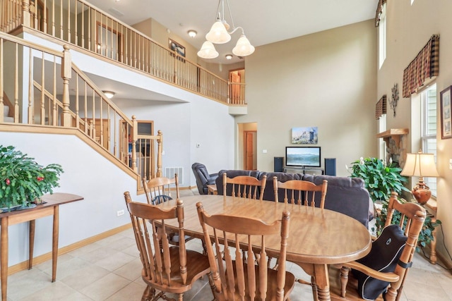 8610 Pebble Creek Ct, Wonder Lake, IL 60097 - dining area with a towering ceiling, tile patterned floors, stairs, baseboards, and a chandelier