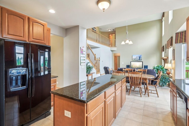 8610 Pebble Creek Ct, Wonder Lake, IL 60097 - kitchen featuring black refrigerator with ice dispenser, dark stone countertops, a center island, stainless steel dishwasher, and light tile patterned floors