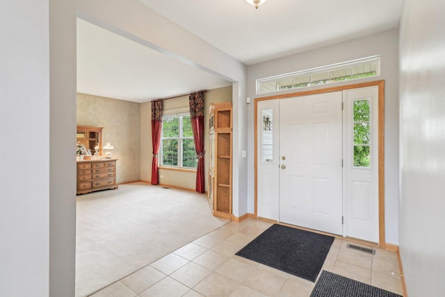 8610 Pebble Creek Ct, Wonder Lake, IL 60097 - foyer with light colored carpet, light tile patterned floors, and baseboards