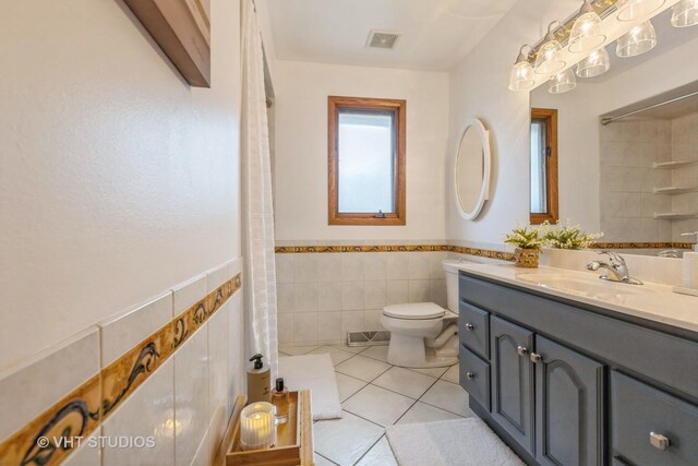 13136 Sage Ct, Homer Glen, IL 60491 - full bathroom featuring tile walls, tile patterned floors, toilet, vanity, and wainscoting