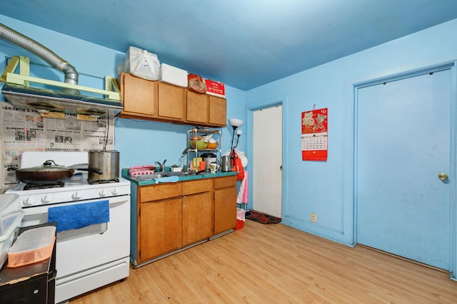 3307 S Wallace St, Chicago, IL 60616 - kitchen with white range with gas stovetop, light wood finished floors, and brown cabinets