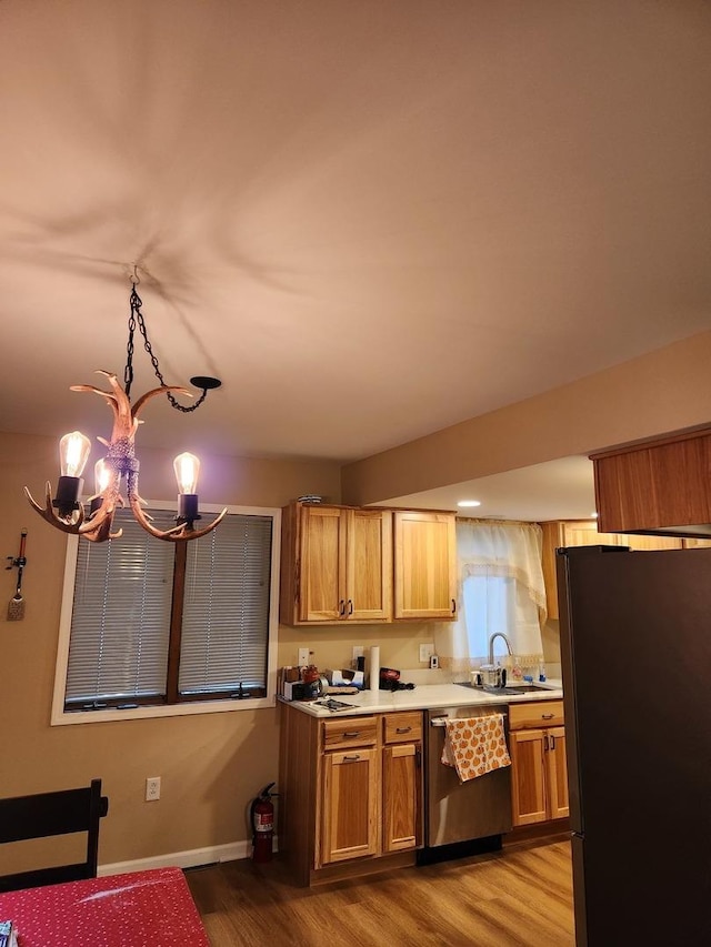 22 Cedar Ln, Putnam, IL 61560 - kitchen featuring stainless steel appliances, a sink, a chandelier, light countertops, and wood finished floors