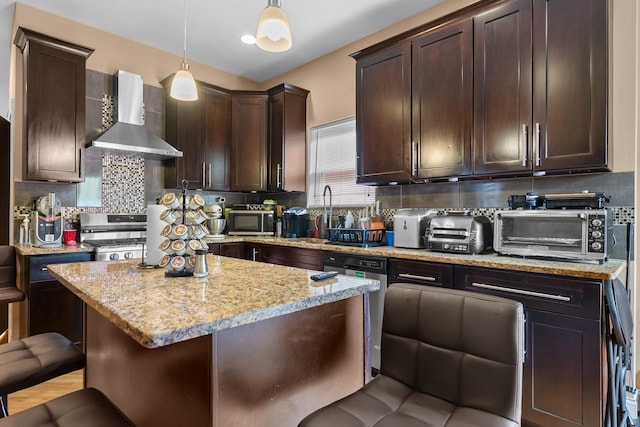 7424 S Euclid Ave, Chicago, IL 60649 - kitchen featuring wall chimney range hood, appliances with stainless steel finishes, dark brown cabinets, light stone counters, and decorative backsplash