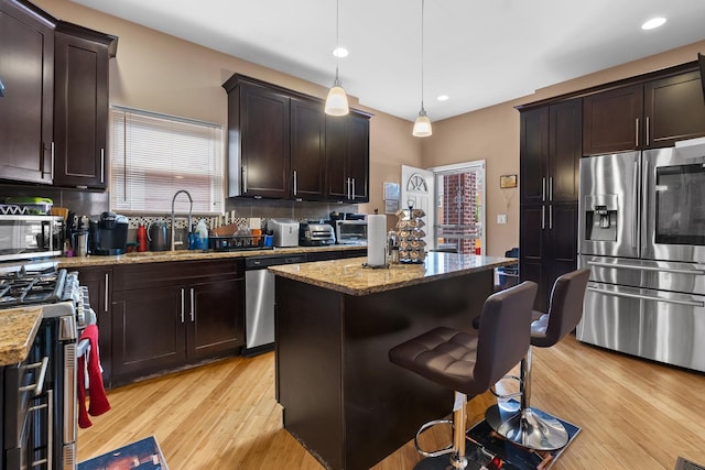 7424 S Euclid Ave, Chicago, IL 60649 - kitchen featuring stainless steel appliances, tasteful backsplash, light stone counters, dark brown cabinetry, and light wood-style flooring
