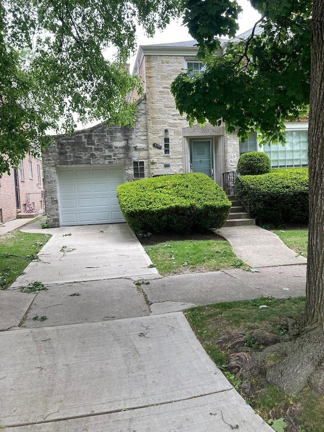 6139 N Monticello Ave, Chicago, IL 60659 - view of front of property with stone siding, concrete driveway, and an attached garage