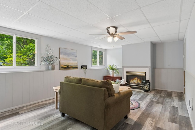 6S024 Westwind Dr, Naperville, IL 60563 - living room with a drop ceiling, ceiling fan, wainscoting, wood finished floors, and a tiled fireplace