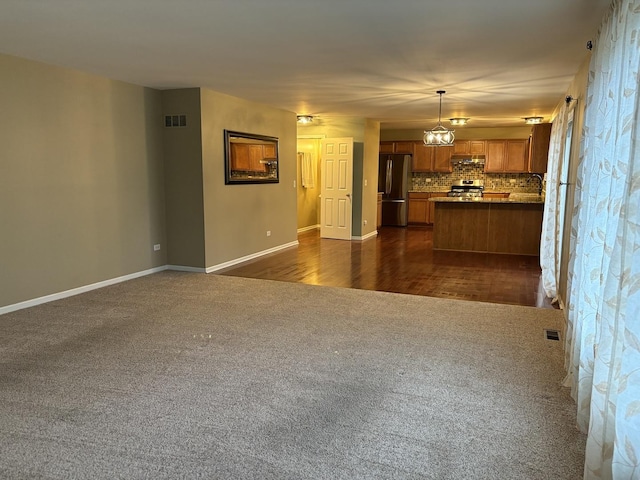 2804 Misty Brook Ln, Joliet, IL 60432 - unfurnished living room featuring dark colored carpet, baseboards, and a sink
