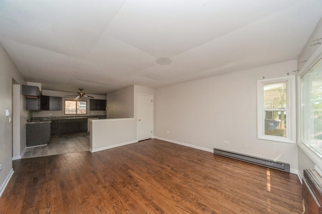 948 Carney Ave, Waukegan, IL 60085 - unfurnished living room with baseboard heating, dark wood finished floors, a ceiling fan, baseboards, and a baseboard radiator
