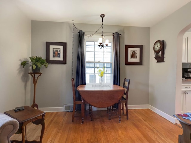 505 S Oakland Ave, Villa Park, IL 60181 - dining area with arched walkways, light wood-type flooring, a chandelier, and baseboards