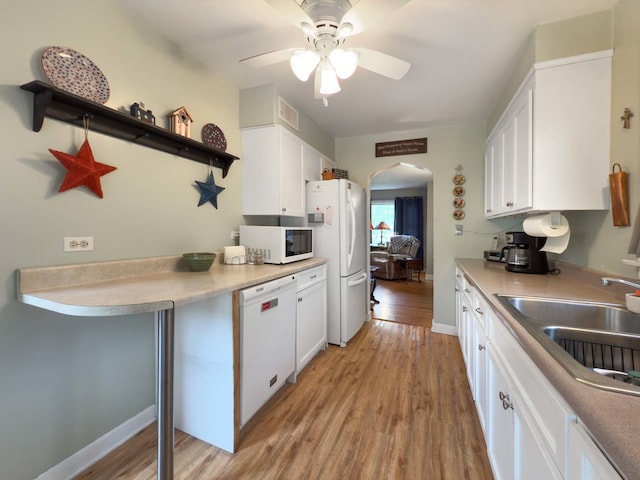 505 S Oakland Ave, Villa Park, IL 60181 - kitchen featuring white appliances, arched walkways, a sink, light wood-style floors, and white cabinetry
