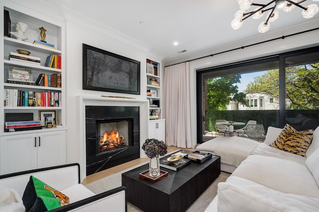 1719 N Burling St Unit 2S, Chicago, IL 60614 - living room featuring built in shelves, a lit fireplace, and a chandelier
