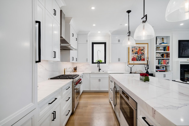 1719 N Burling St Unit 2S, Chicago, IL 60614 - kitchen with appliances with stainless steel finishes, wall chimney range hood, white cabinets, pendant lighting, and recessed lighting