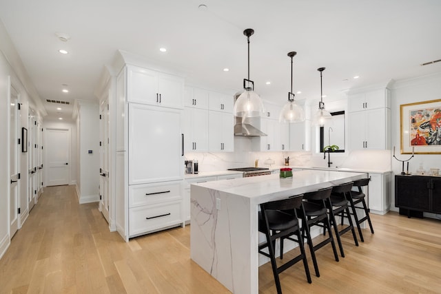 1719 N Burling St Unit 2S, Chicago, IL 60614 - kitchen featuring a center island, white cabinets, decorative backsplash, recessed lighting, and light wood-style floors