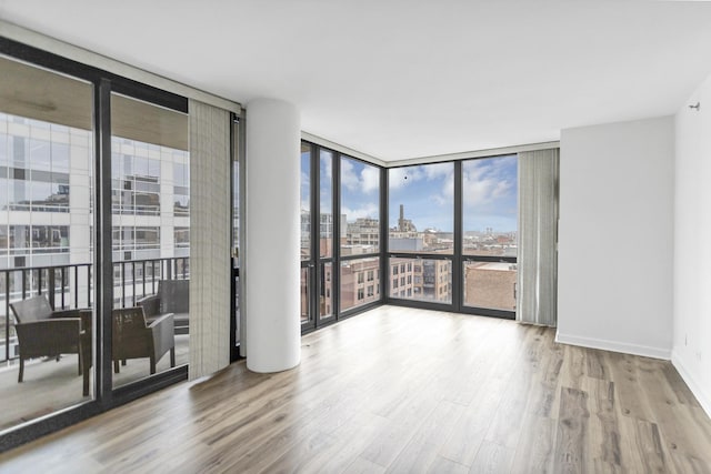 210 S Desplaines St Unit 1102, Chicago, IL 60661 - unfurnished room with floor to ceiling windows, a view of city, wood finished floors, and baseboards