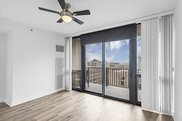 210 S Desplaines St Unit 1102, Chicago, IL 60661 - spare room with expansive windows, wood finished floors, a ceiling fan, and baseboards