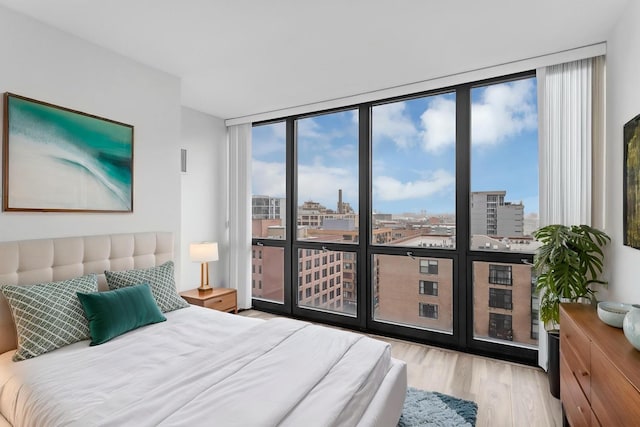 210 S Desplaines St Unit 1102, Chicago, IL 60661 - bedroom with floor to ceiling windows, a city view, wood finished floors, and multiple windows