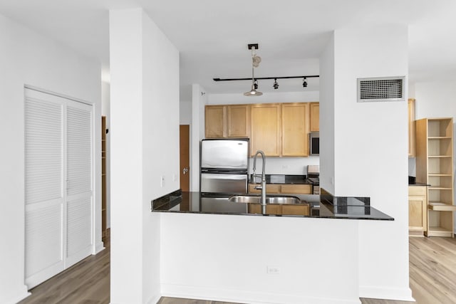 210 S Desplaines St Unit 1102, Chicago, IL 60661 - kitchen with appliances with stainless steel finishes, wood finished floors, a sink, a peninsula, and dark stone countertops