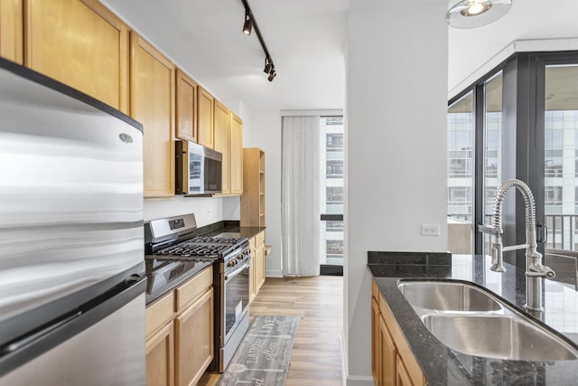 210 S Desplaines St Unit 1102, Chicago, IL 60661 - kitchen with stainless steel appliances, a sink, light wood-style flooring, and dark stone countertops