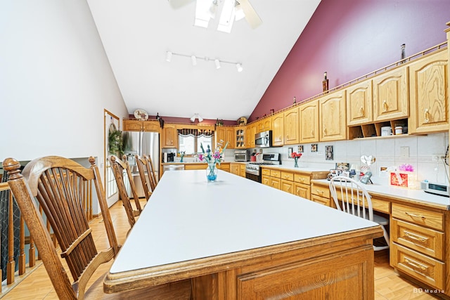 9039 S Central Ave, Oak Lawn, IL 60453 - kitchen featuring appliances with stainless steel finishes, a ceiling fan, a kitchen island, light countertops, and high vaulted ceiling