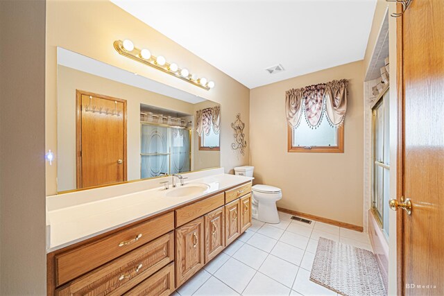9039 S Central Ave, Oak Lawn, IL 60453 - full bathroom featuring vanity, toilet, tile patterned flooring, baseboards, and enclosed tub / shower combo
