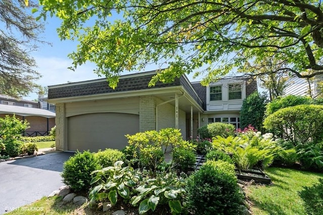 1682 Cavell Ave, Highland Park, IL 60035 - view of property exterior with brick siding, a shingled roof, mansard roof, and an attached garage