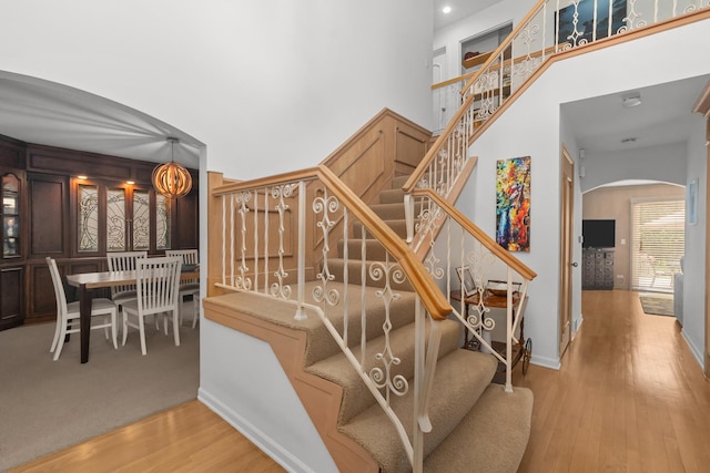 1682 Cavell Ave, Highland Park, IL 60035 - staircase featuring arched walkways, wood finished floors, a towering ceiling, and baseboards