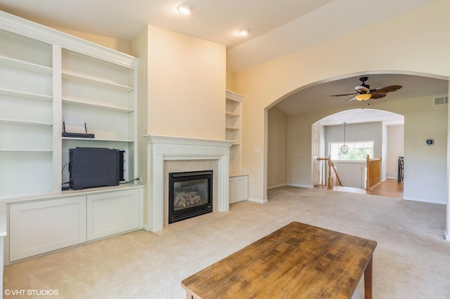 1040 Fairway Dr, Fox Lake, IL 60020 - unfurnished living room with light carpet, ceiling fan, arched walkways, and a tile fireplace