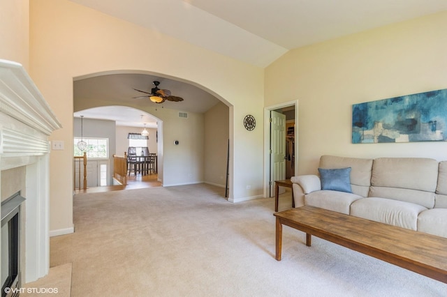 1040 Fairway Dr, Fox Lake, IL 60020 - living room featuring arched walkways, ceiling fan, light colored carpet, a fireplace with flush hearth, and lofted ceiling