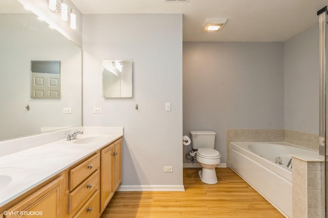 1040 Fairway Dr, Fox Lake, IL 60020 - bathroom featuring wood finished floors, double vanity, a bath, toilet, and baseboards