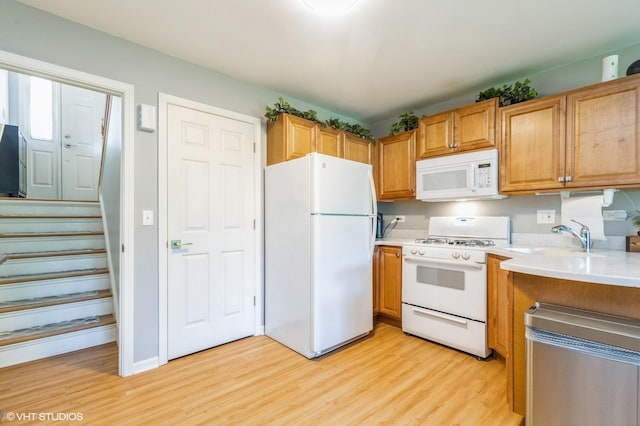 1040 Fairway Dr, Fox Lake, IL 60020 - kitchen featuring white appliances, a sink, light wood-style flooring, light countertops, and brown cabinets