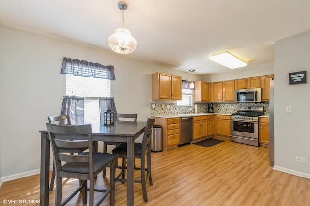 1040 Fairway Dr, Fox Lake, IL 60020 - kitchen featuring appliances with stainless steel finishes, tasteful backsplash, light wood-type flooring, and baseboards