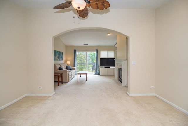 1040 Fairway Dr, Fox Lake, IL 60020 - living room featuring arched walkways, light colored carpet, a ceiling fan, and a fireplace with flush hearth