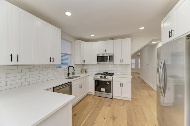 4345 N Mcvicker Ave, Chicago, IL 60634 - kitchen with stainless steel appliances, a sink, white cabinets, light wood-style floors, and recessed lighting