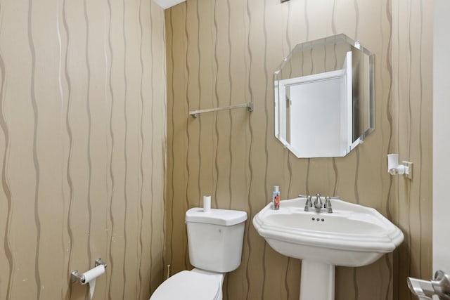 half bathroom with toilet and a sink