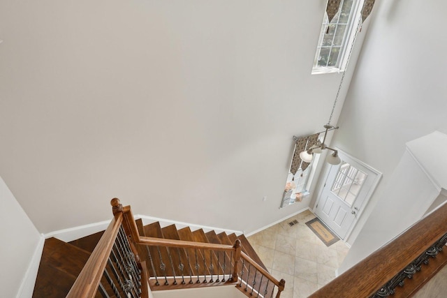stairs with a towering ceiling and baseboards