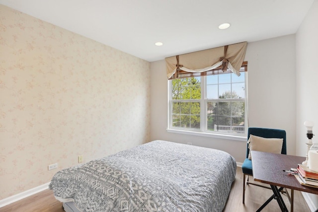 bedroom featuring wood finished floors, wallpapered walls, baseboards, and recessed lighting