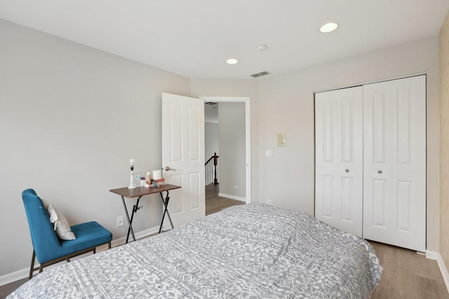 bedroom with wood finished floors, baseboards, a closet, and recessed lighting