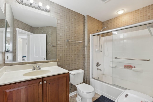 bathroom with toilet, vanity, and shower / bath combination with glass door