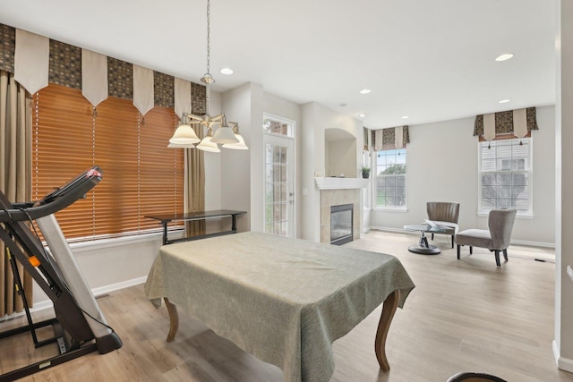dining area with baseboards, recessed lighting, light wood-style flooring, a fireplace, and pool table
