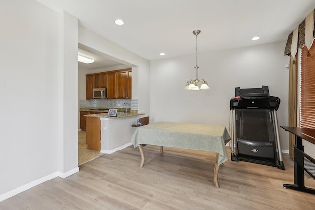 bedroom featuring light wood-style floors, baseboards, recessed lighting, and a sink